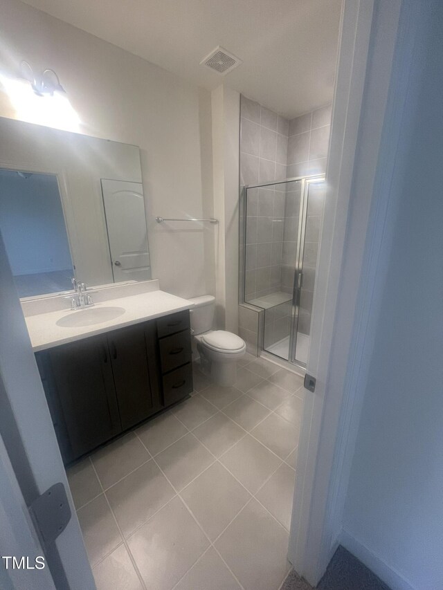 bathroom featuring walk in shower, tile patterned flooring, vanity, and toilet