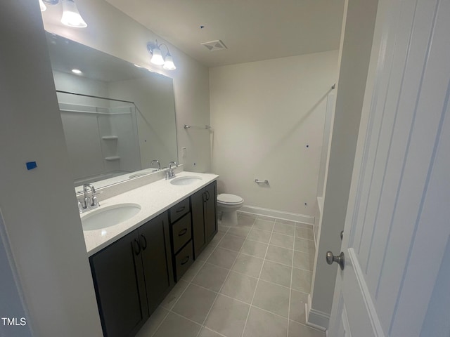 bathroom featuring vanity, tile patterned flooring, walk in shower, and toilet