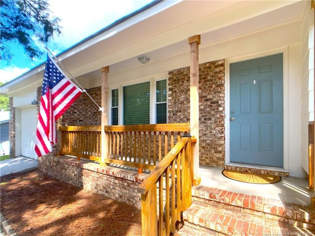 entrance to property featuring a porch and a garage