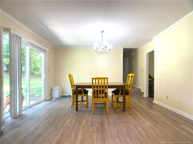 dining area featuring an inviting chandelier, a textured ceiling, ornamental molding, and dark hardwood / wood-style flooring