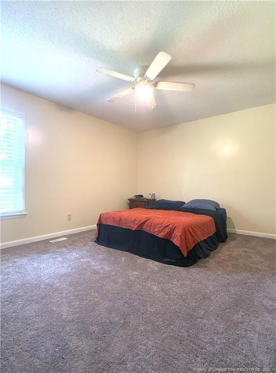 bedroom with carpet floors, a textured ceiling, and ceiling fan