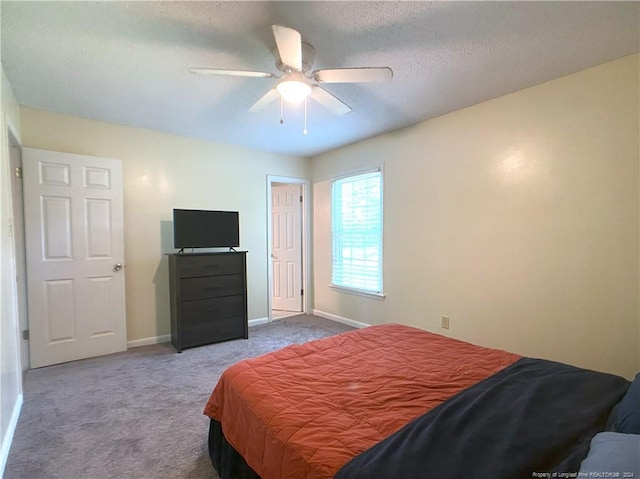 carpeted bedroom with ceiling fan and a textured ceiling