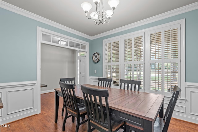 dining area featuring an inviting chandelier, hardwood / wood-style floors, and ornamental molding