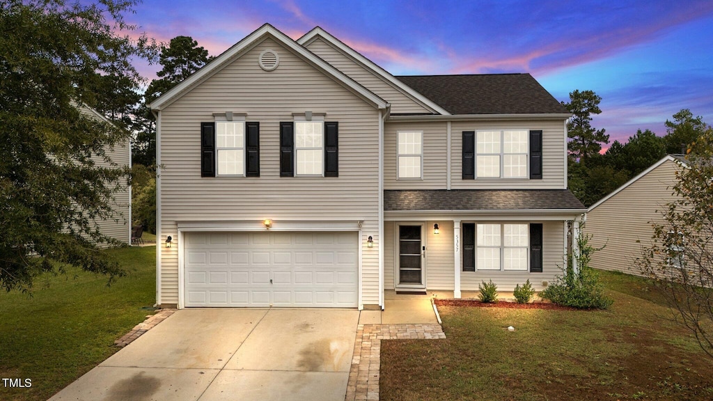 view of front property featuring a garage and a yard