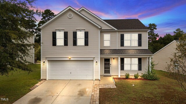 view of front property featuring a garage and a yard