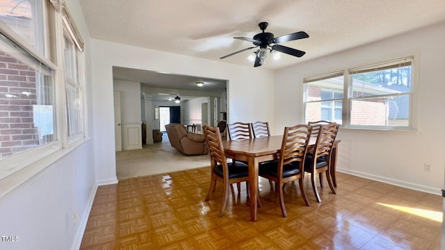 dining room featuring ceiling fan, a textured ceiling, and light parquet flooring