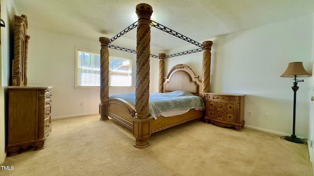 bedroom with a textured ceiling and light carpet