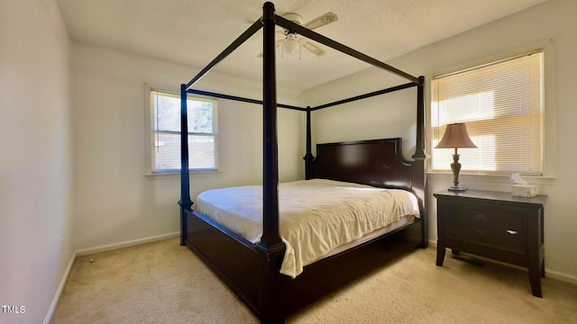 bedroom featuring multiple windows, light carpet, and ceiling fan