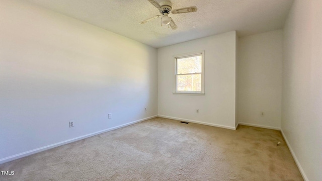 carpeted spare room with ceiling fan and a textured ceiling