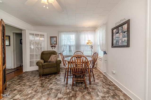 dining space with ornamental molding and ceiling fan