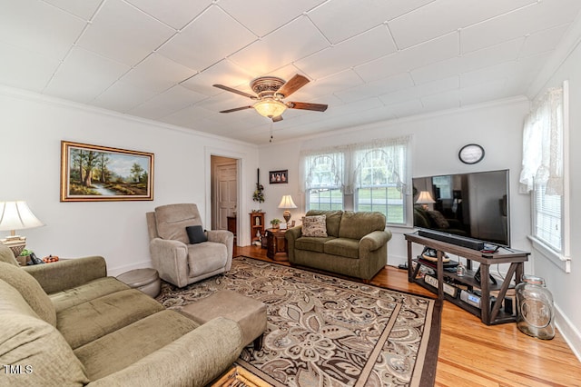 living room featuring plenty of natural light, ornamental molding, and hardwood / wood-style flooring