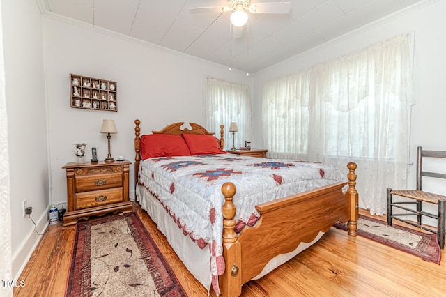 bedroom featuring crown molding, ceiling fan, and wood-type flooring