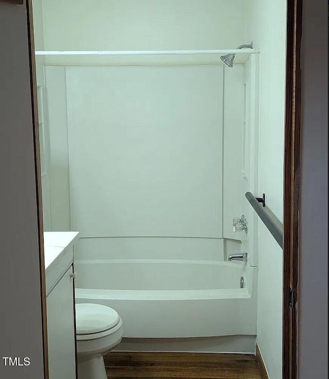 full bath featuring toilet, shower / washtub combination, wood finished floors, and vanity