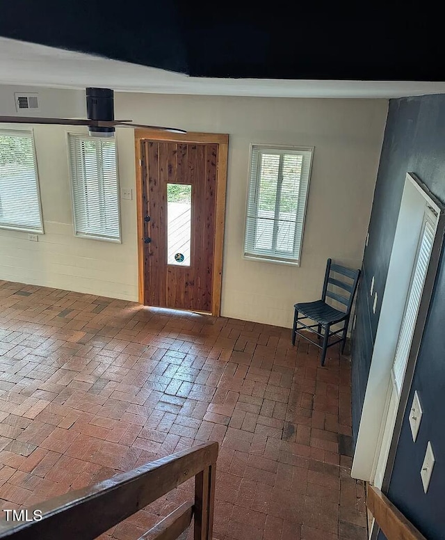 entryway featuring brick floor and visible vents