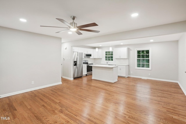 unfurnished living room featuring light wood-type flooring and ceiling fan