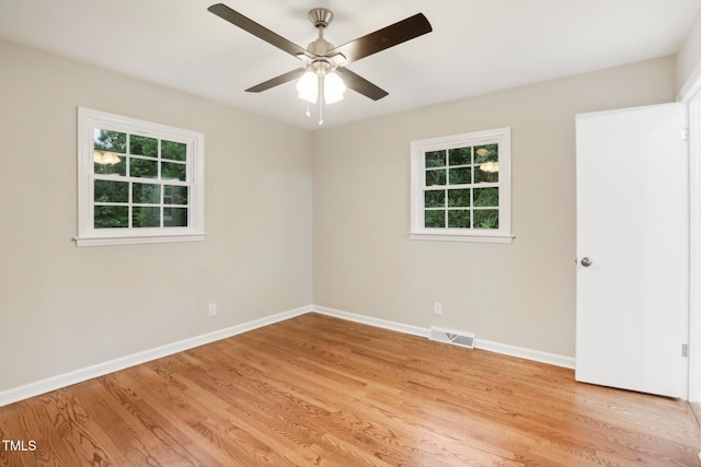 empty room with light hardwood / wood-style floors, plenty of natural light, and ceiling fan