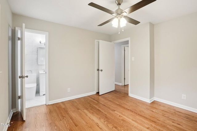 unfurnished bedroom featuring ensuite bath, ceiling fan, and light hardwood / wood-style flooring