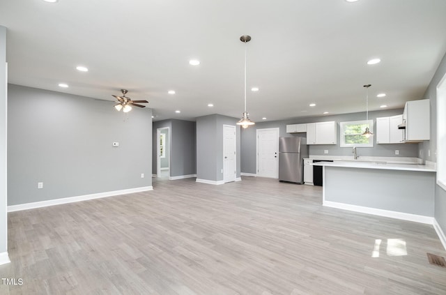 kitchen featuring stainless steel refrigerator, ceiling fan, hanging light fixtures, light hardwood / wood-style floors, and white cabinets