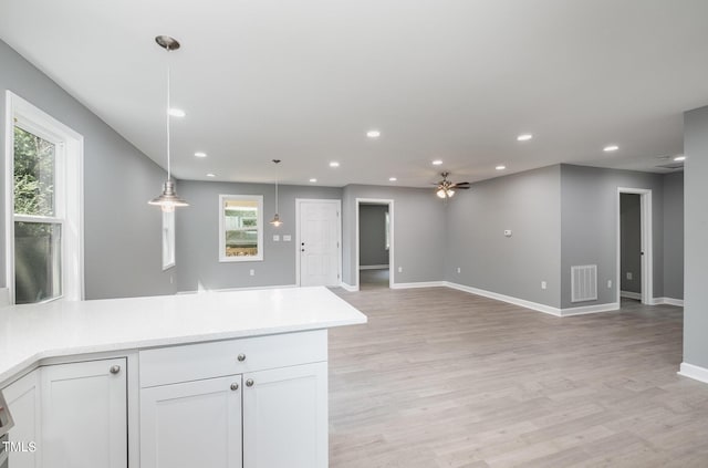 kitchen featuring a wealth of natural light, decorative light fixtures, white cabinetry, and ceiling fan