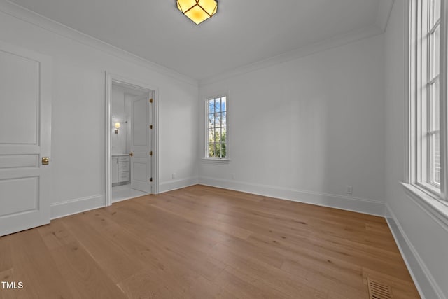 unfurnished bedroom featuring light wood finished floors, baseboards, visible vents, and ornamental molding