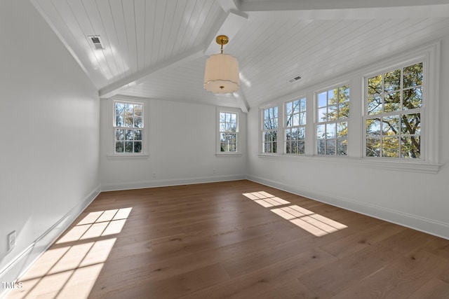 unfurnished room with visible vents, vaulted ceiling with beams, baseboards, and hardwood / wood-style flooring