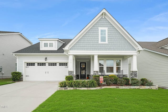 craftsman-style home featuring a garage, a front lawn, and covered porch