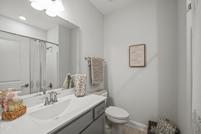 bathroom with a shower with curtain, vanity, hardwood / wood-style floors, and toilet