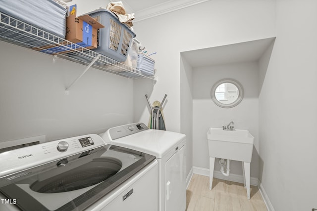 washroom featuring crown molding, light wood-type flooring, and independent washer and dryer