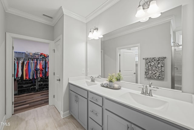 bathroom with vanity, ornamental molding, a chandelier, and walk in shower