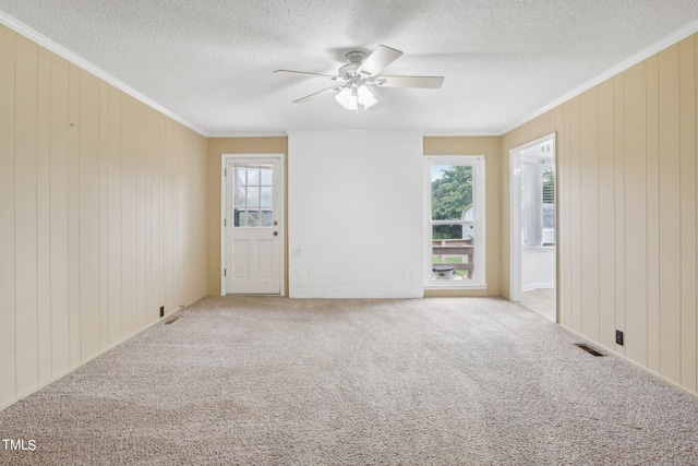 unfurnished room with carpet floors, crown molding, ceiling fan, and plenty of natural light