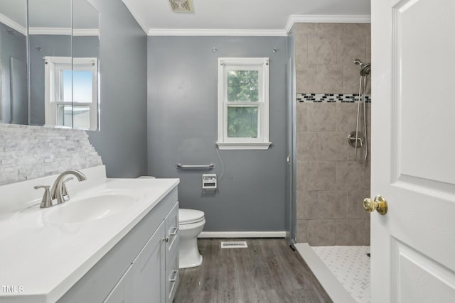 bathroom with vanity, hardwood / wood-style floors, toilet, and tiled shower