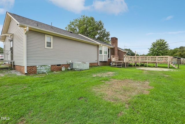 view of side of property featuring a wooden deck and a yard