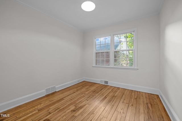 empty room with light hardwood / wood-style flooring and crown molding