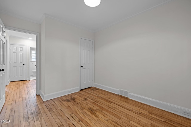 unfurnished room with light wood-type flooring and crown molding