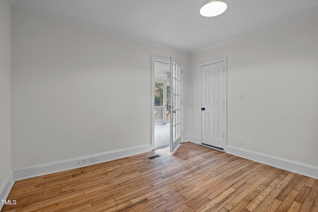 empty room with ornamental molding and light hardwood / wood-style flooring