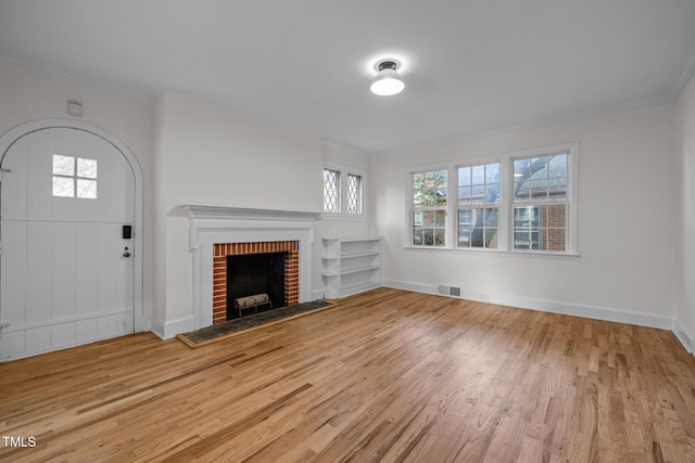 unfurnished living room with crown molding, light hardwood / wood-style floors, and a fireplace