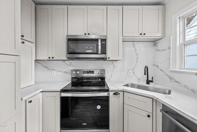 kitchen with white cabinetry, sink, appliances with stainless steel finishes, and tasteful backsplash