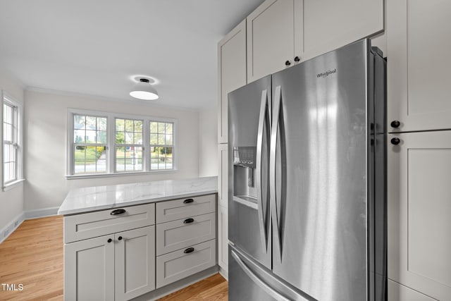 kitchen with light hardwood / wood-style floors, stainless steel fridge, and plenty of natural light