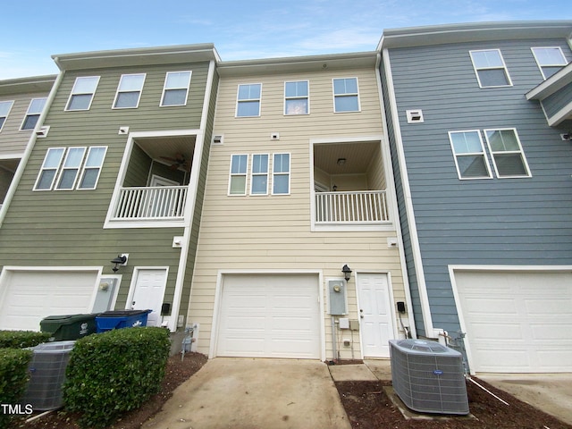 view of front facade featuring cooling unit, a balcony, and a garage