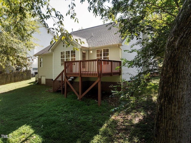 rear view of property featuring a wooden deck and a yard