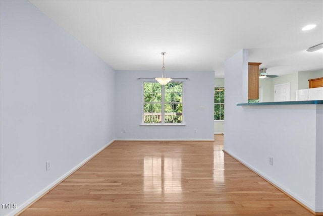 unfurnished dining area with light hardwood / wood-style flooring and ceiling fan