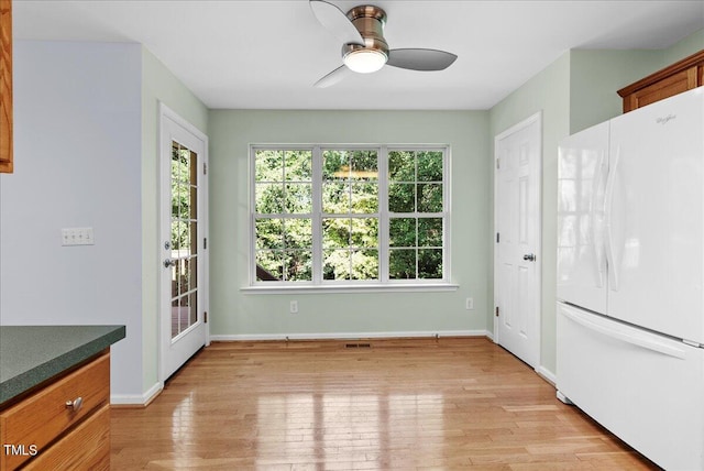 unfurnished dining area featuring light hardwood / wood-style floors and ceiling fan