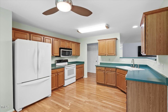 kitchen with white appliances, light hardwood / wood-style flooring, ceiling fan, and sink