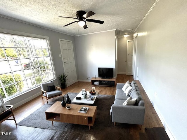 living room with a textured ceiling, ceiling fan, hardwood / wood-style flooring, and crown molding