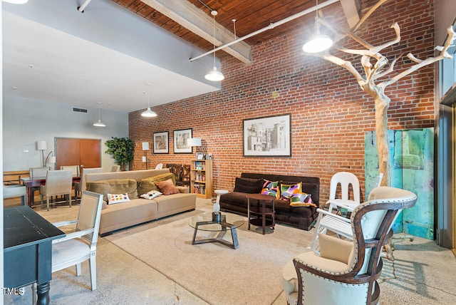 living room with beam ceiling, brick wall, and a high ceiling