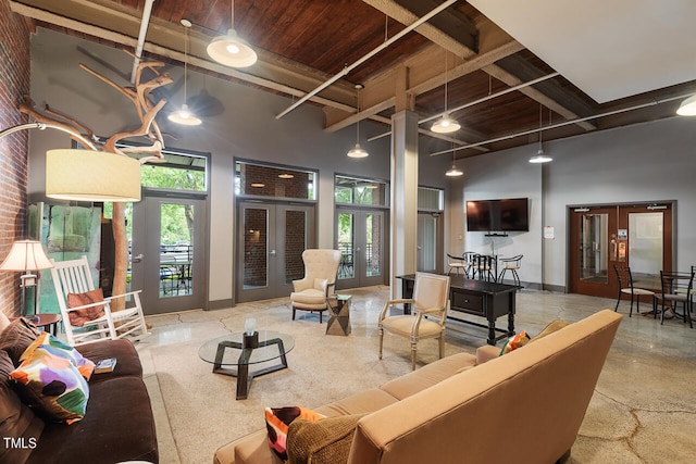 living room featuring beam ceiling, french doors, and a towering ceiling