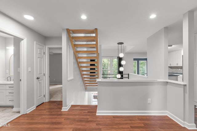 interior space with white cabinetry, wood finished floors, and recessed lighting