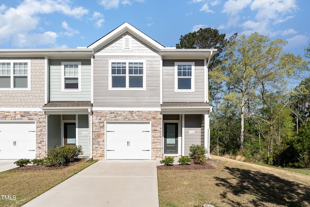 view of property with a garage and a front lawn