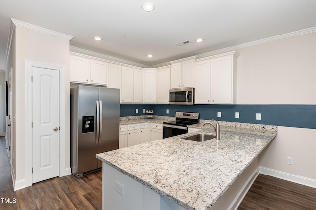 kitchen with white cabinets, sink, stainless steel appliances, and kitchen peninsula