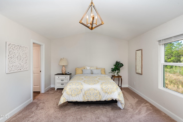 bedroom with carpet flooring, a notable chandelier, and vaulted ceiling